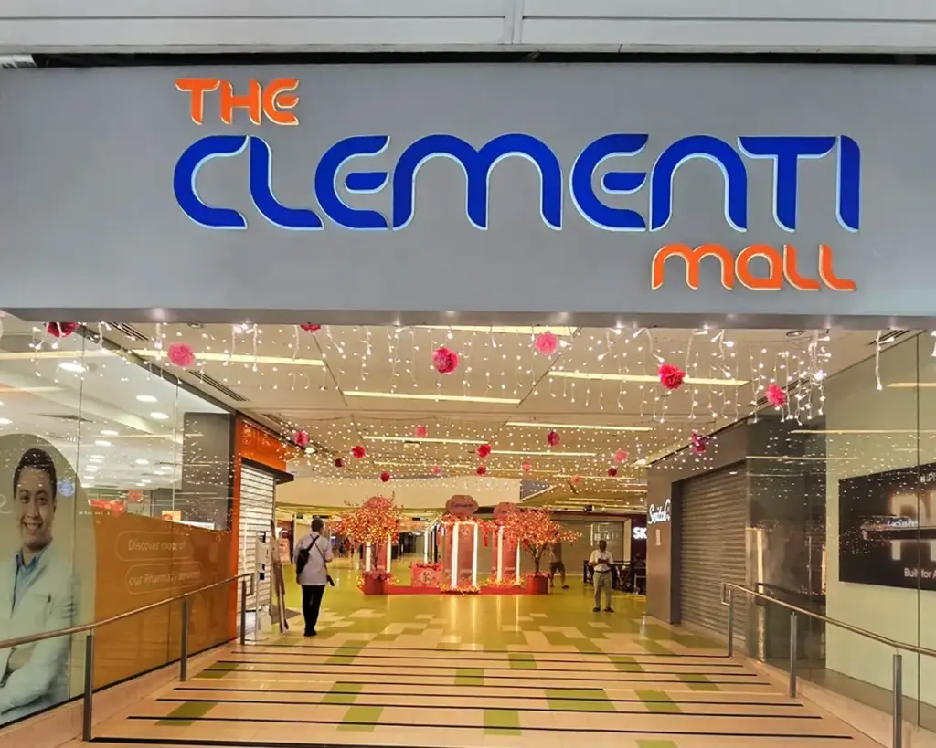 The exterior signage of a modern shopping mall with bold, illuminated lettering, set against a sleek building facade in a busy urban area.