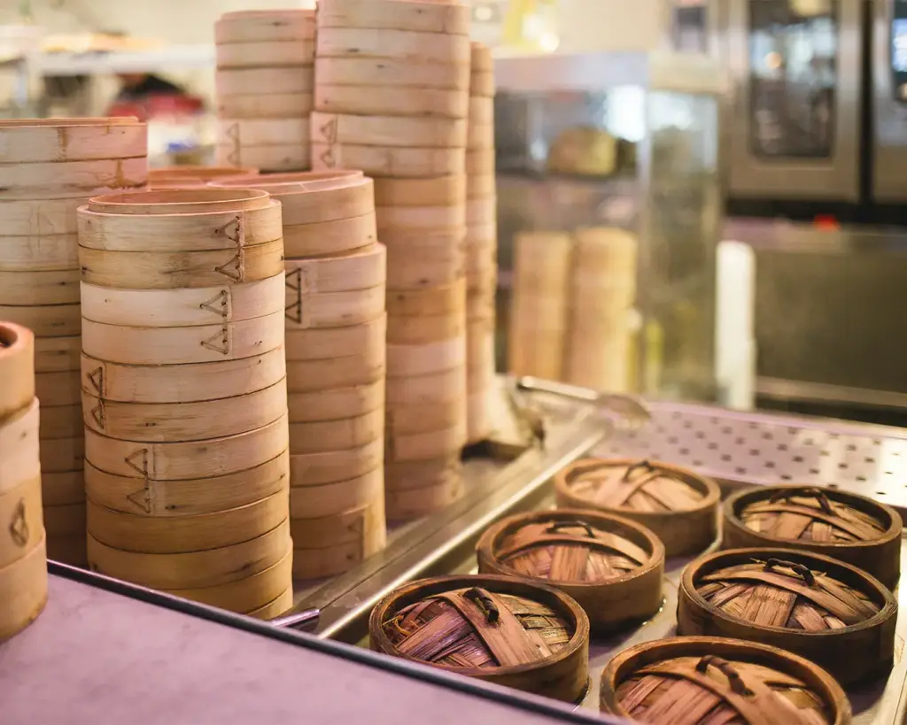 A traditional dim sum stall showcasing bamboo steamers stacked with freshly steamed dumplings, buns, and other dim sum dishes ready to be served.