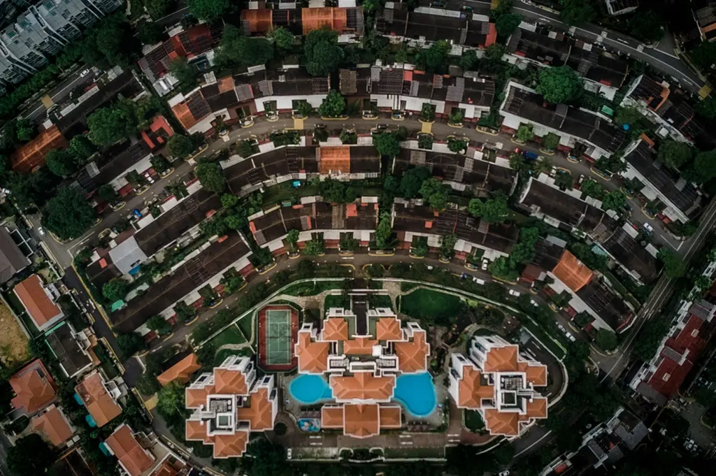 Aerial view of Holland Village Singapore featuring curved residential streets, low-rise shophouses, lush greenery and modern condominium buildings in a dense urban neighborhood landscape