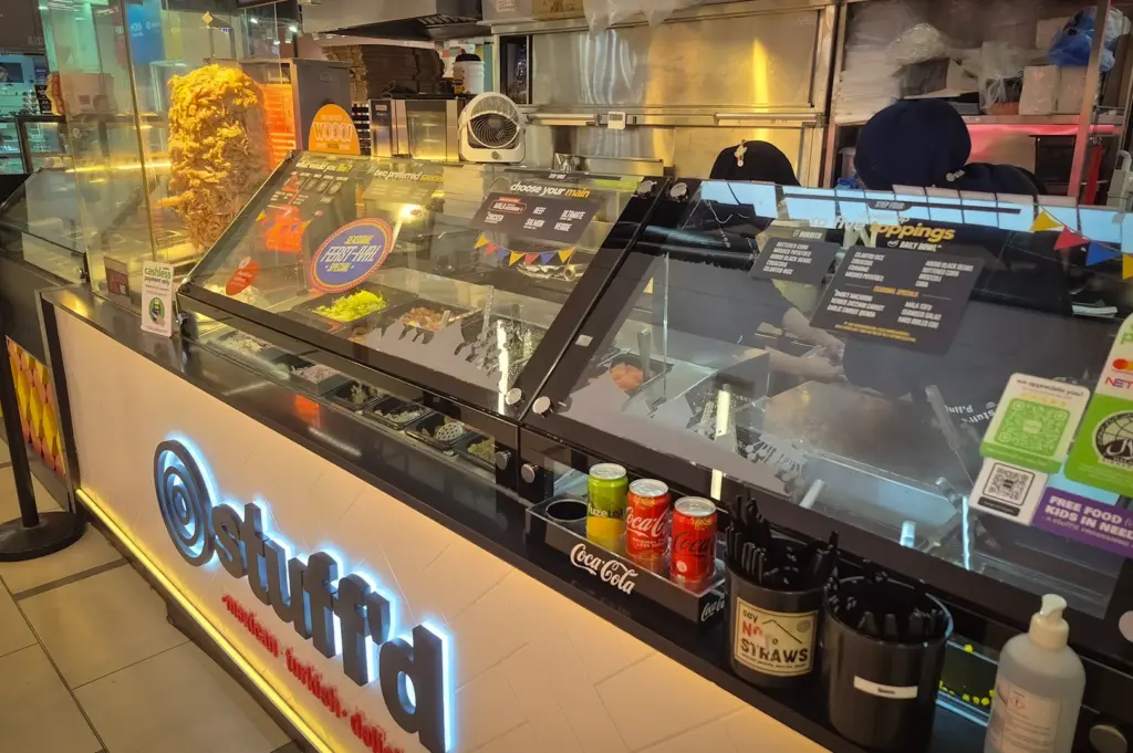 Stuff’d fast casual food counter in Singapore serving kebab wraps, burritos and rice bowls with fresh ingredients and halal-certified preparation station visible inside the outlet