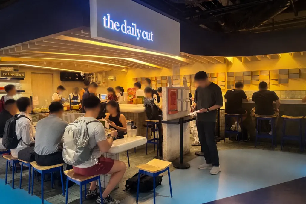 Interior of The Daily Cut restaurant with customers dining and ordering food in a modern casual cafe setting