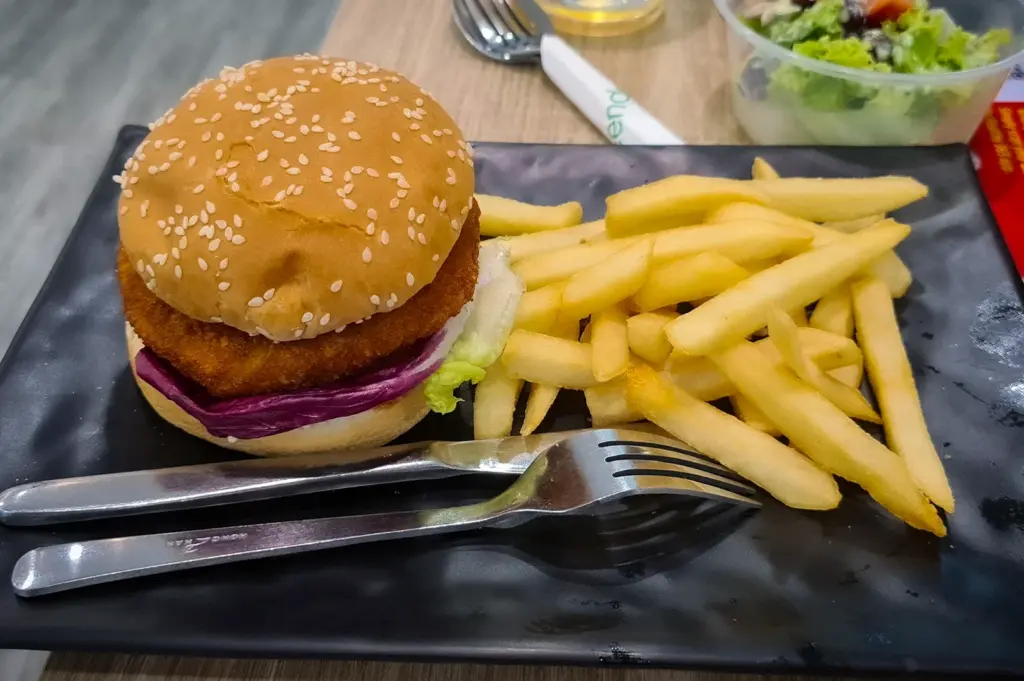 Vegetarian burger with crispy plant-based patty, lettuce, and sesame bun served with french fries at Green Dot near Bugis MRT Singapore