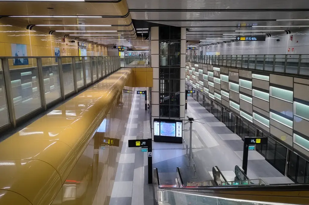 Bayshore MRT Station on Singapore's Thomson-East Coast Line, featuring modern underground platforms, escalators, glass safety barriers, and contemporary transit architecture.