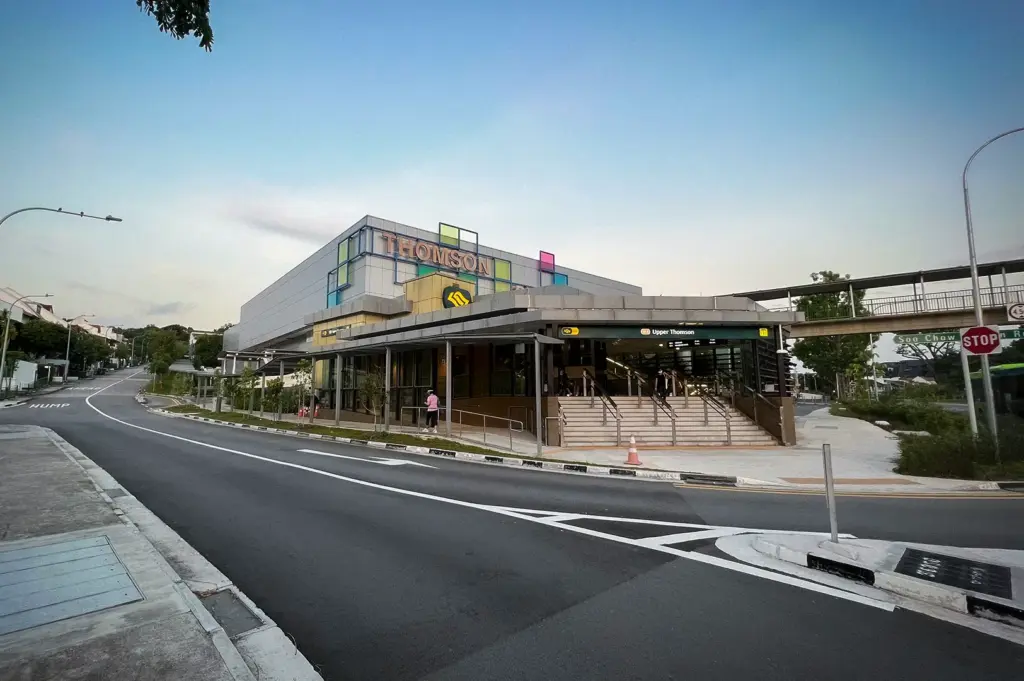 Entrance to Upper Thomson MRT Station in Singapore with Thomson Plaza in the background, featuring modern transit infrastructure, pedestrian access, and the Thomson-East Coast Line station exterior.