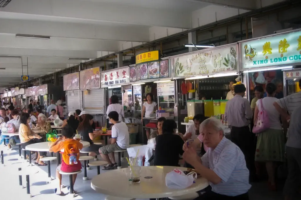 Busy dining area inside Marine Parade Central Market in Singapore, featuring hawker food stalls, communal seating, and patrons enjoying local dishes in a traditional food centre setting.