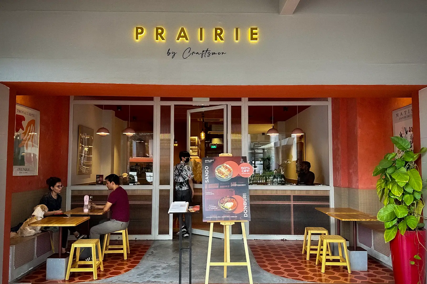 Front entrance of Prairie by Craftsmen café in Singapore featuring outdoor seating, warm modern interiors, and a welcoming neighborhood café atmosphere.