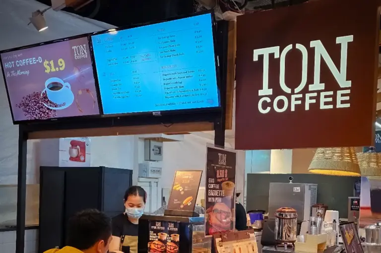TON Coffee signage displayed above the specialty coffee counter in Singapore, featuring the café’s illuminated brand logo and menu boards.