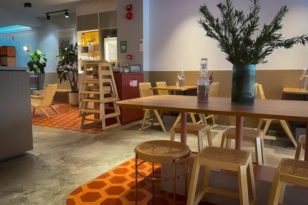 Modern interior of Prairie by Craftsmen café in Singapore featuring wooden furniture, warm earthy décor, indoor plants, and spacious contemporary dining seating.