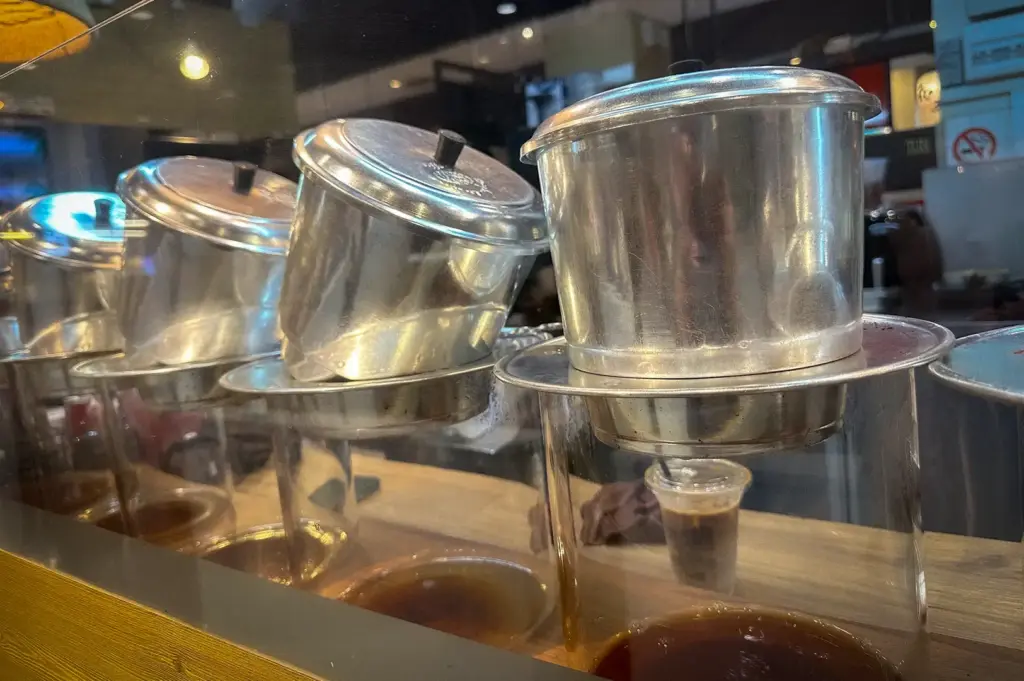 Traditional Vietnamese coffee drip filters brewing fresh coffee at TON Coffee Singapore, showcasing stainless steel phin filters used for handcrafted specialty coffee.