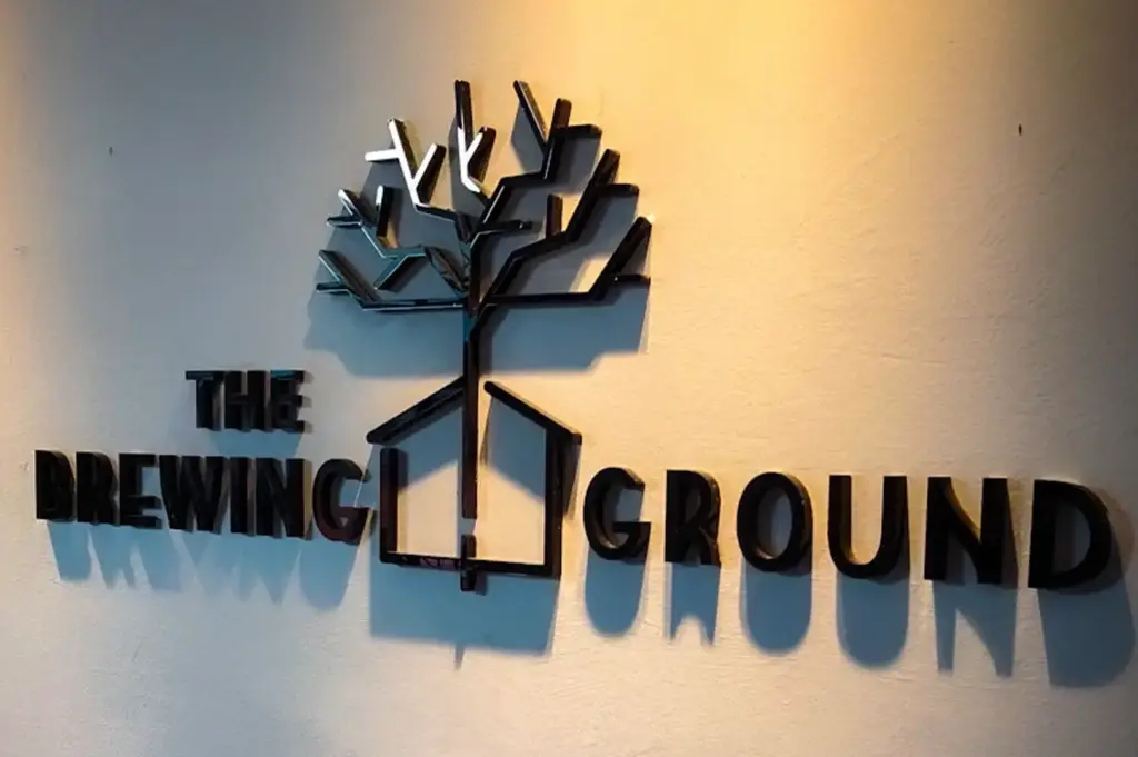 The Brewing Ground logo displayed on an interior wall inside the café in Joo Chiat, Singapore.