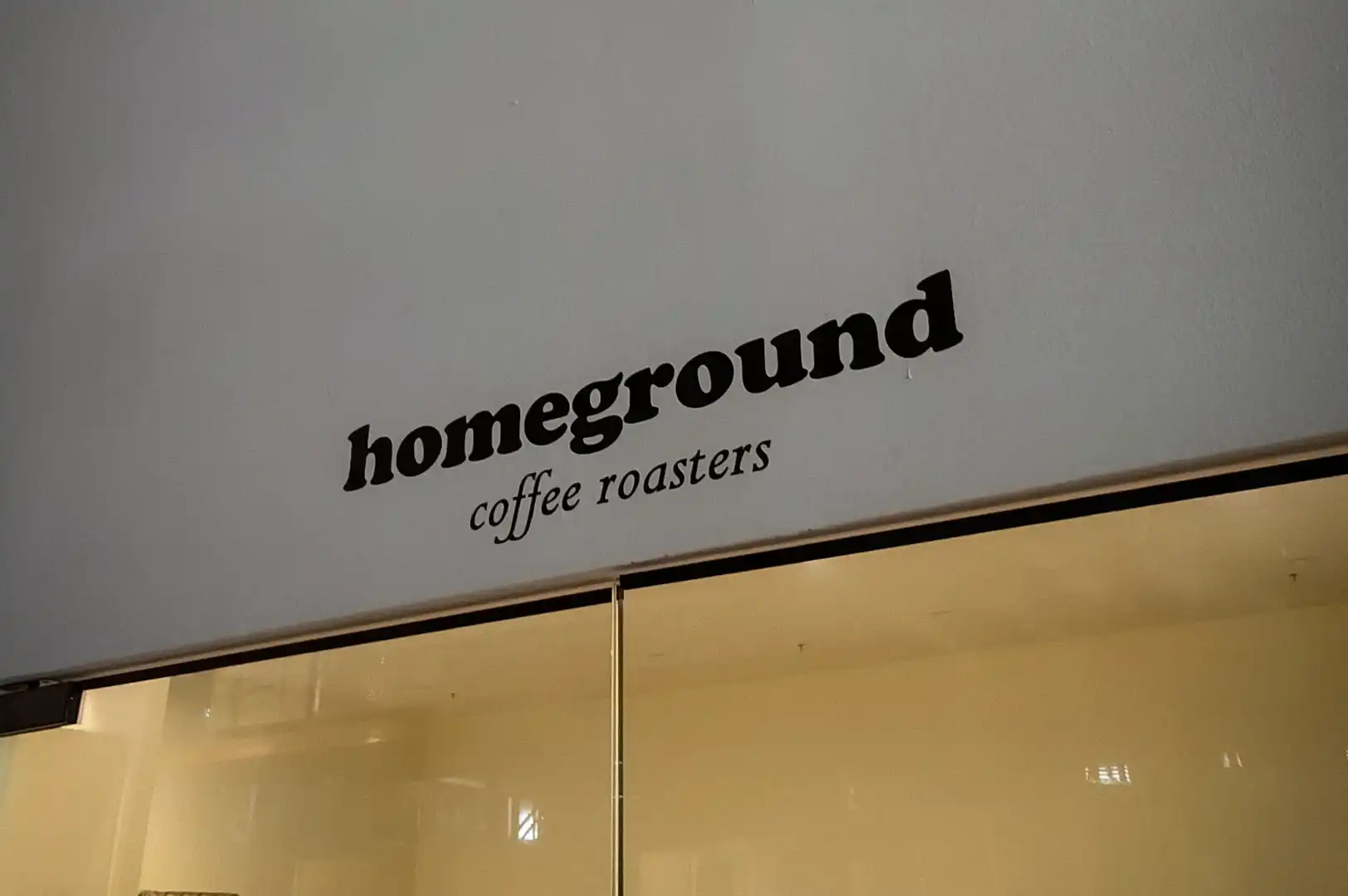 Homeground Coffee Roasters cafe interior with coffee counter, espresso machines, and coffee bags on display
