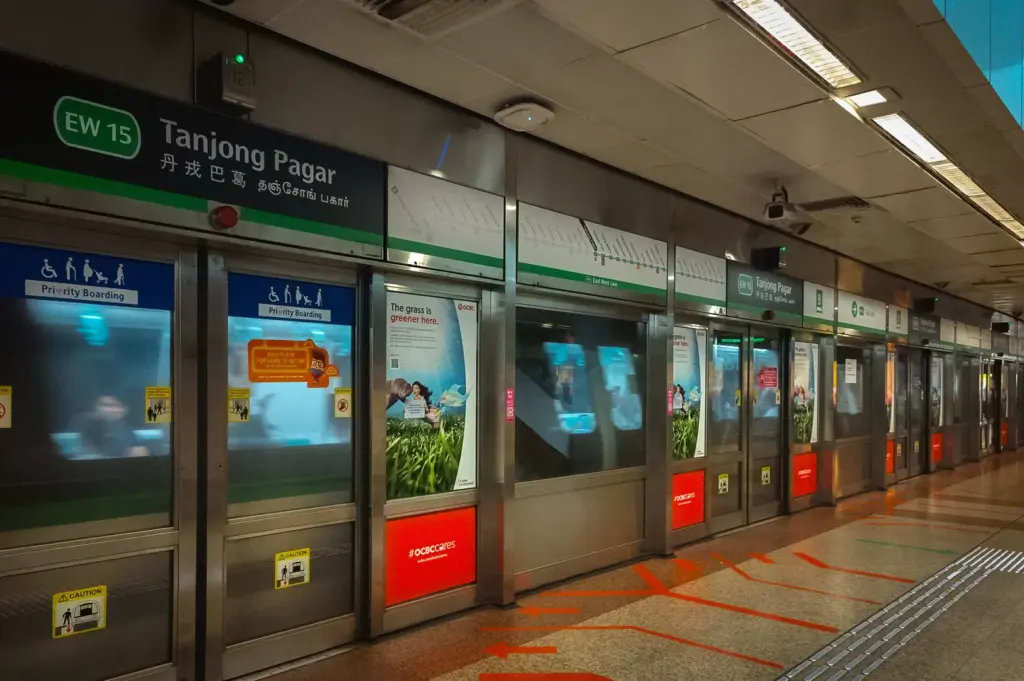Tanjong Pagar MRT station platform in Singapore with East West Line signs, platform screen doors, and directional markings