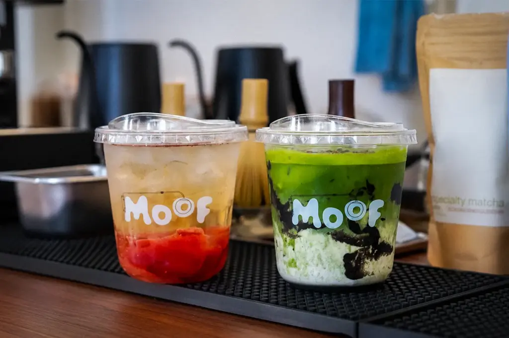 Moof Singapore matcha and refreshing fruit drink served in branded cups at the cafe counter