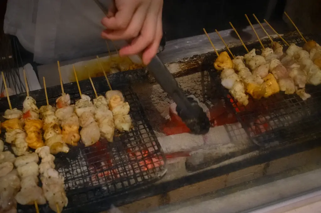 Sushi to Sumi Singapore grilled seafood skewers cooking over a charcoal grill with glowing embers