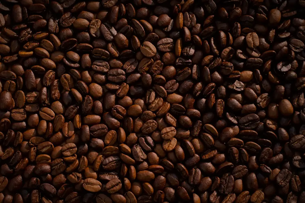 Close-up of roasted coffee beans filling the frame, showcasing rich brown tones and the textured surface of freshly roasted whole coffee beans.