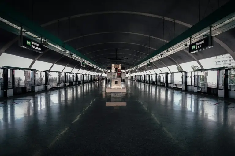 Symmetrical view of the elevated train platform, track screen doors, and vaulted ceiling at Kembangan MRT Station on the East West Line in Singapore