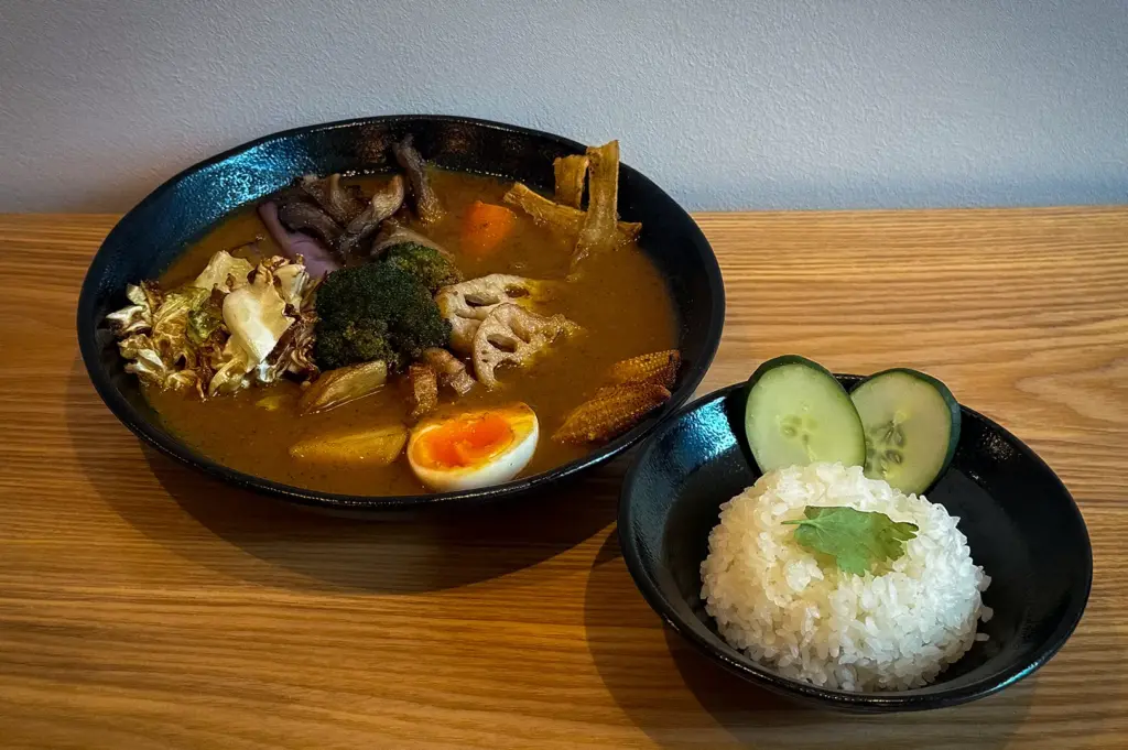 Hokkaido soup curry with vegetables, mushrooms, lotus root, broccoli, baby corn, egg, and steamed Japanese rice.
