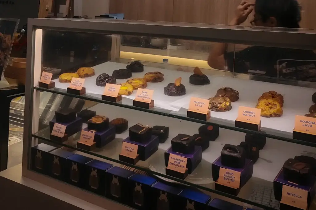FYP Cafe Singapore dessert display featuring assorted cookies, brownies, lava cakes, and pastries in a glass showcase.