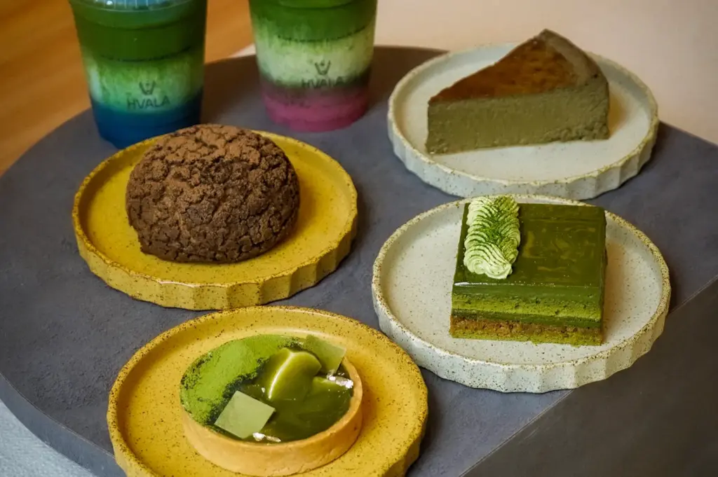 Selection of matcha desserts including tart, sliced cake, cream puff, and layered iced green tea drinks at Hvala 111 Somerset.