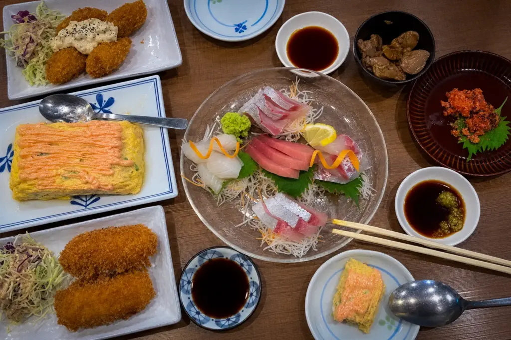 Japanese izakaya spread at Morinaga Izakaya Singapore featuring assorted sashimi, breaded seafood, mentaiko omelette, and side dishes.