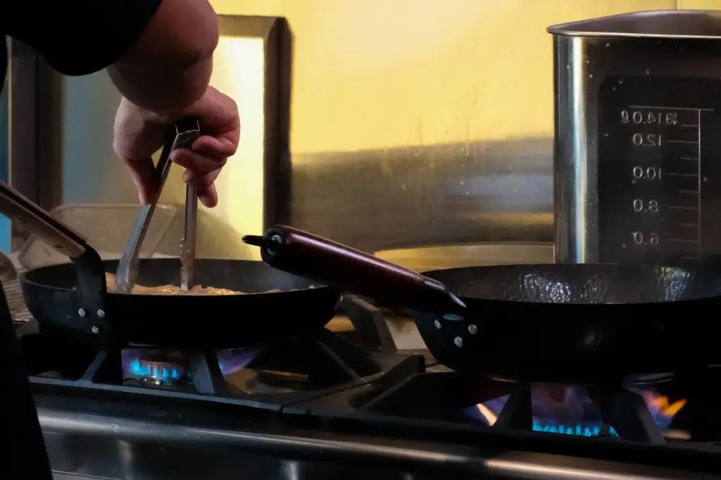 Soup Curry by Ki Setsu kitchen with staff preparing curry in pans over a gas stove.