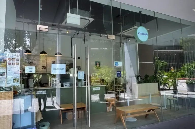 Exterior storefront view of Snap Cafe (The Clift) - Specialty Coffee, Freshly-whisked Matcha, Sourdough Toasties in Singapore featuring a clean glass facade, modern minimalist signage, and natural light spilling into the cozy interior