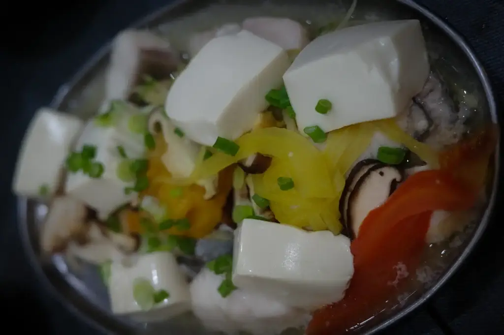 Fresh ingredients including soft tofu blocks, fish slices, tomatoes, mushrooms, and yellow pickled vegetables arranged on a tray at Hup Lok near Tiong Bahru
