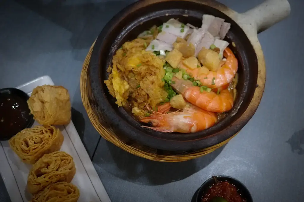 Claypot prawn noodles topped with fresh prawns, pork slices, crispy egg, and pork crackling at Hup Lok near Tiong Bahru, served with a side of crispy fried beancurd rolls and chili dip