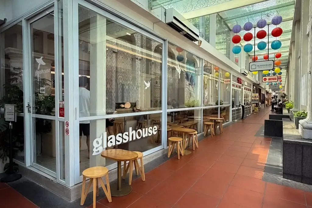Covered outdoor walkway and glass exterior facade decorated with colorful hanging lanterns at Glasshouse cafe in CHIJMES, Singapore